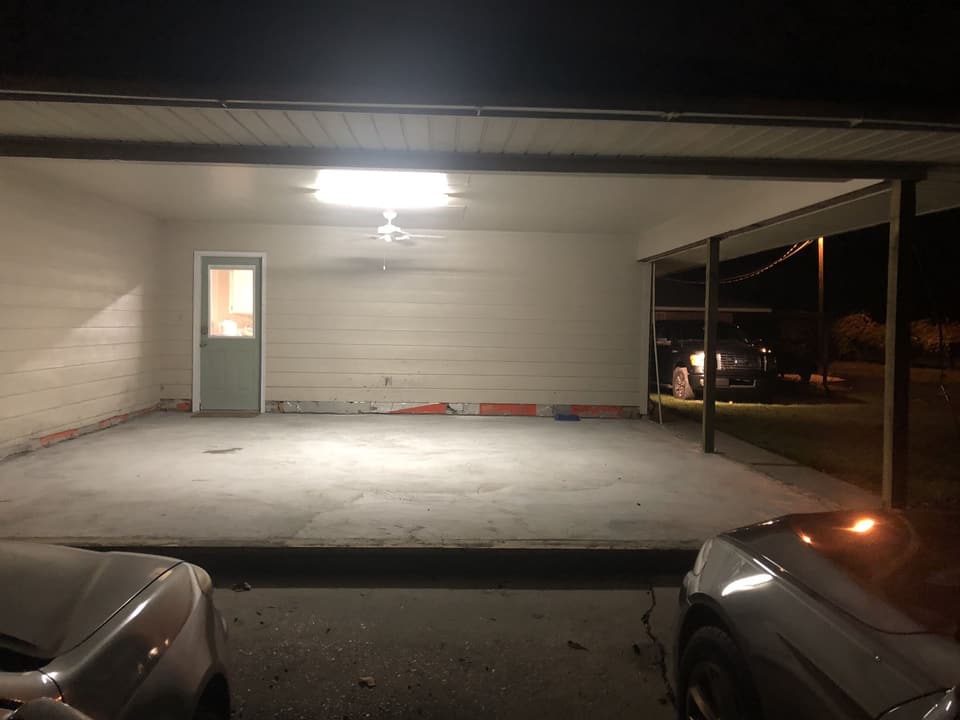 Same carport at night, stripped back to the slab and wall framing during the enclosure