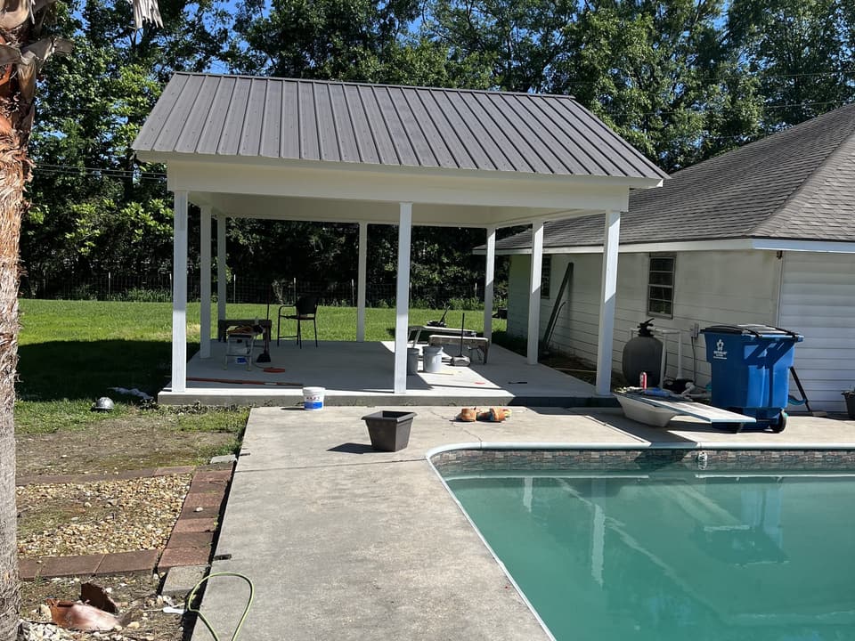 Finished pavilion with a metal roof beside the pool